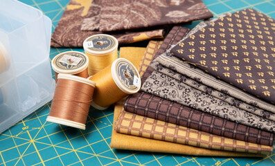 Sewing thread, colored fabric with various patterns and colors for sewing, quilting and crafts.
