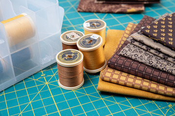 Sewing thread, colored fabric with various patterns and colors for sewing, quilting and crafts.