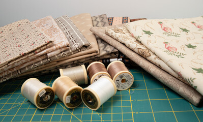 Sewing thread, colored fabric with various patterns and colors for sewing, quilting and crafts.