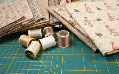 Sewing thread, colored fabric with various patterns and colors for sewing, quilting and crafts.