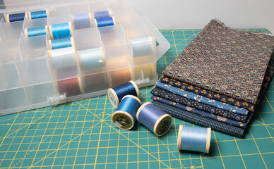 Sewing thread, colored fabric with various patterns and colors for sewing, quilting and crafts.