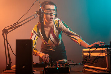 Disc jockey mixing techno music with turntables, musical performer playing sounds to produce melody...