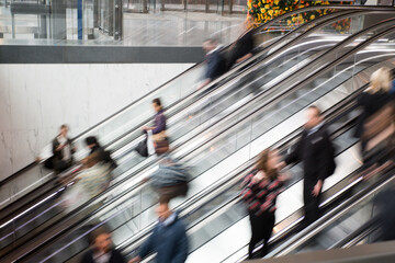 Unrecognizable blurred people on escalator in shopping center