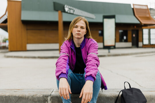 Young  woman in depression sitting outdoors .