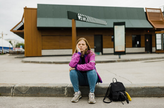 Young  woman sitting outdoors .