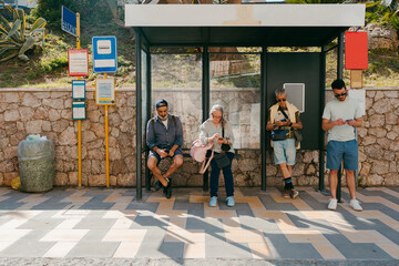 People waiting in bus stop checking their smartphones