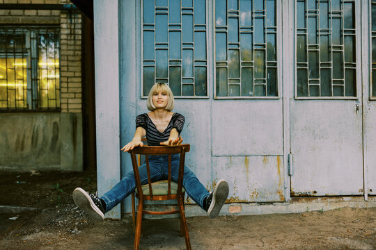 blond young woman sitting on the old chair
