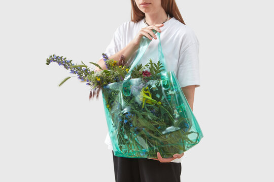 Woman holding recycled bag with flowers.