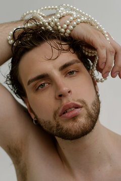 Hot bearded stylish guy with accessories looks to the camera