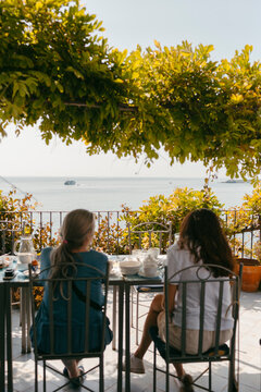 Two women having breakfast in restaurant terrace by the sea