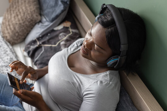 music app, woman in headphones listens music on smartphone at home