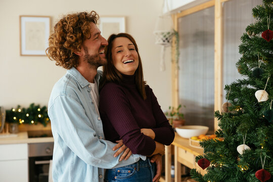 Optimistic couple hugging on Christmas eve