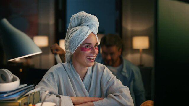 Bathrobe lady laughing workplace remotely closeup. Woman trying ignore husband