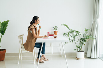 Young female student with book learning at home