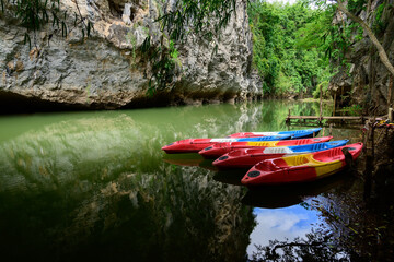 Red kayaks with paddles in them on river Tourist canoes with paddles on the river coast in summer...