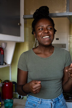 Warm and happy modern young woman in her kitchen