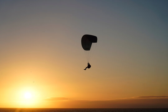 Silhouette of a para-glider on sunset.