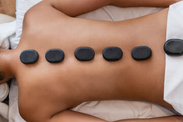 Woman with volcanic stones on her back in a spa.