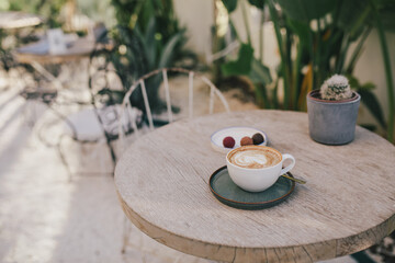 A cup of coffee with candies on the table.