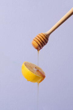 sliced lemon with honey and honey dripper