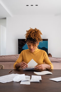 Hispanic woman packing letter into envelope