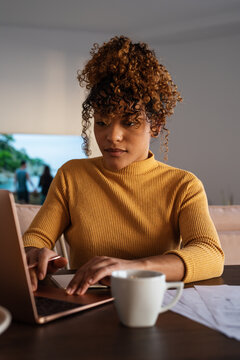 Hispanic freelancer scrolling data on laptop