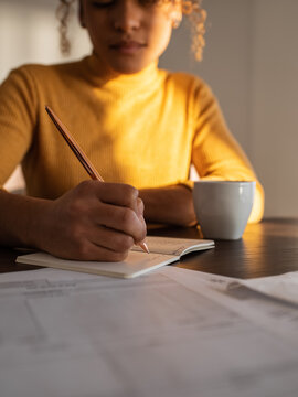 Businesswoman writing down data into notepad in daytime