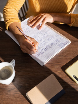 Crop entrepreneur making notes near coffee
