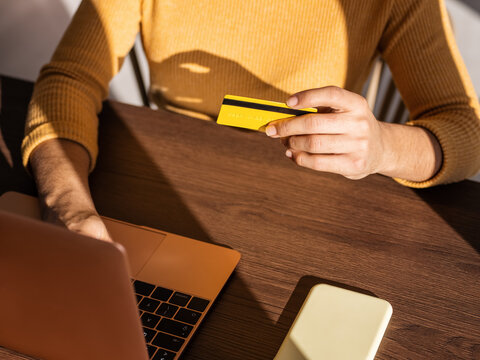 Crop woman with credit card making online payment
