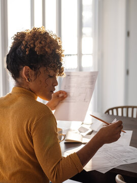 Hispanic businesswoman analyzing financial documents