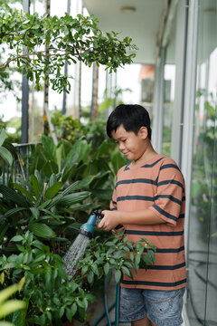 Little boy helping parents to grow herbs and flowers.