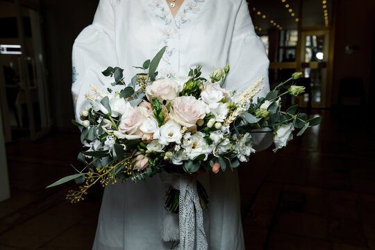 wedding flowers in the hands of the girl and a dark background
