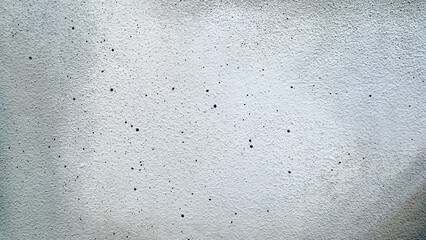 White texture with black dots and grey painted frame. Decorative plaster is painted white and grey and decorated with dots of black paint of different sizes. White-grey textured background.