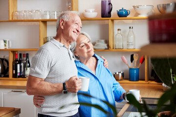 Content mature couple hugging in kitchen