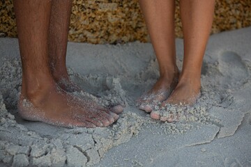 Closeup of a male and female bare feet on the sand