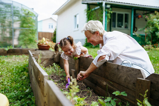 Mom and daughter plant seeds in the garden