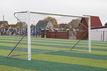 a small green soccer field and a white gate
