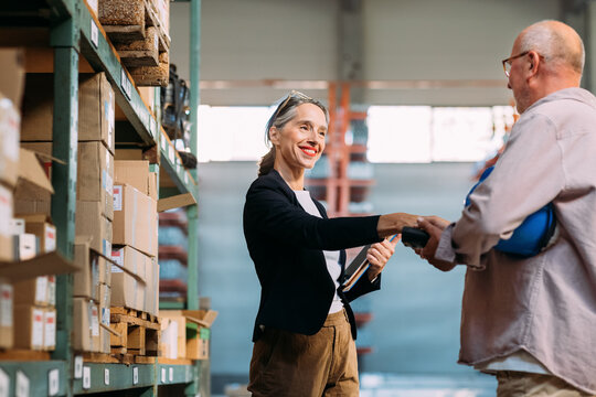 Man and Woman Shaking Hands in Factory  