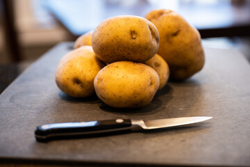 Yukon Gold Potatoes Stacked On Cutting Board
