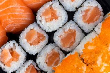 Salmon sushi and sashimi nigiri and maki roll closeup. Delicious japanese food with fresh fish, restaurant delivery set.