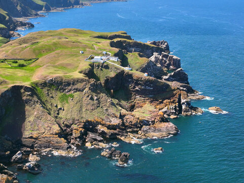 St. Abbs Lighthouse and coastal cliffs aerial view in summer near village of St. Abbs, Berwickshire, Scotland, UK. 