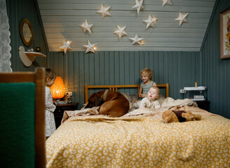  little kids and dog in a bedroom
