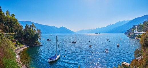 Panorama of Lake Maggiore with moored yachts and foggy Alps, Ascona, Switzerland