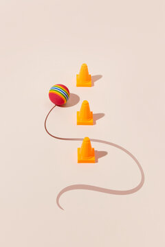 Yellow cones with colorful ball and curved line.