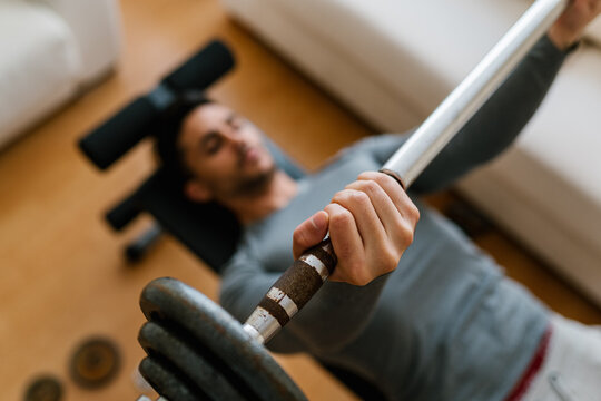 Sportsman lifting barbell on bench