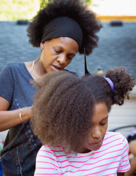 Mother combing her child's kinky curly coily hair