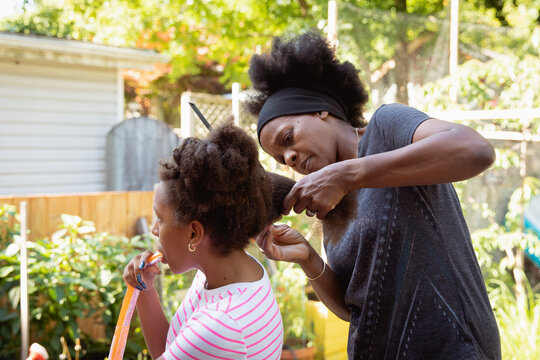 Mother combing her child's kinky curly coily hair