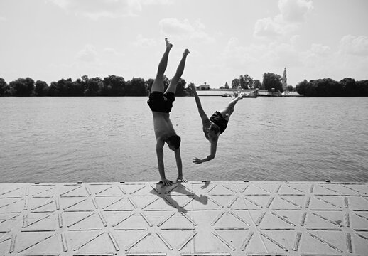 Two young guys doing somersaults into the water