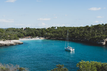Fototapeta na wymiar Amazing bay with blue sea and a white sailboat