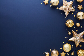 Luxury Christmas flat lay composition. Golden stars, baubles, confetti on dark blue background....